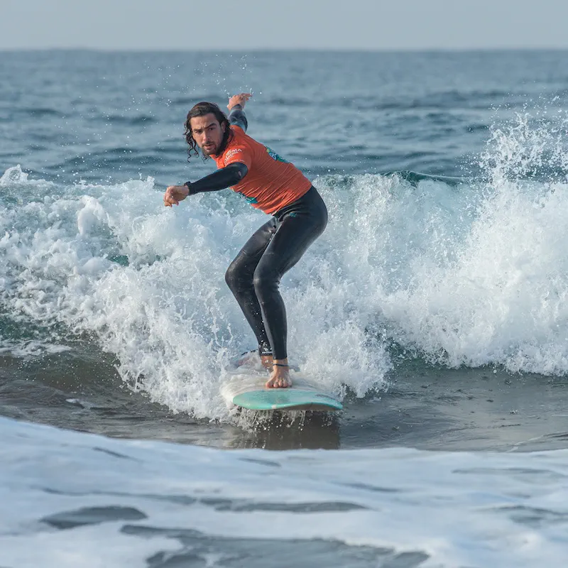 A surfer riding across a small wave on a soft board